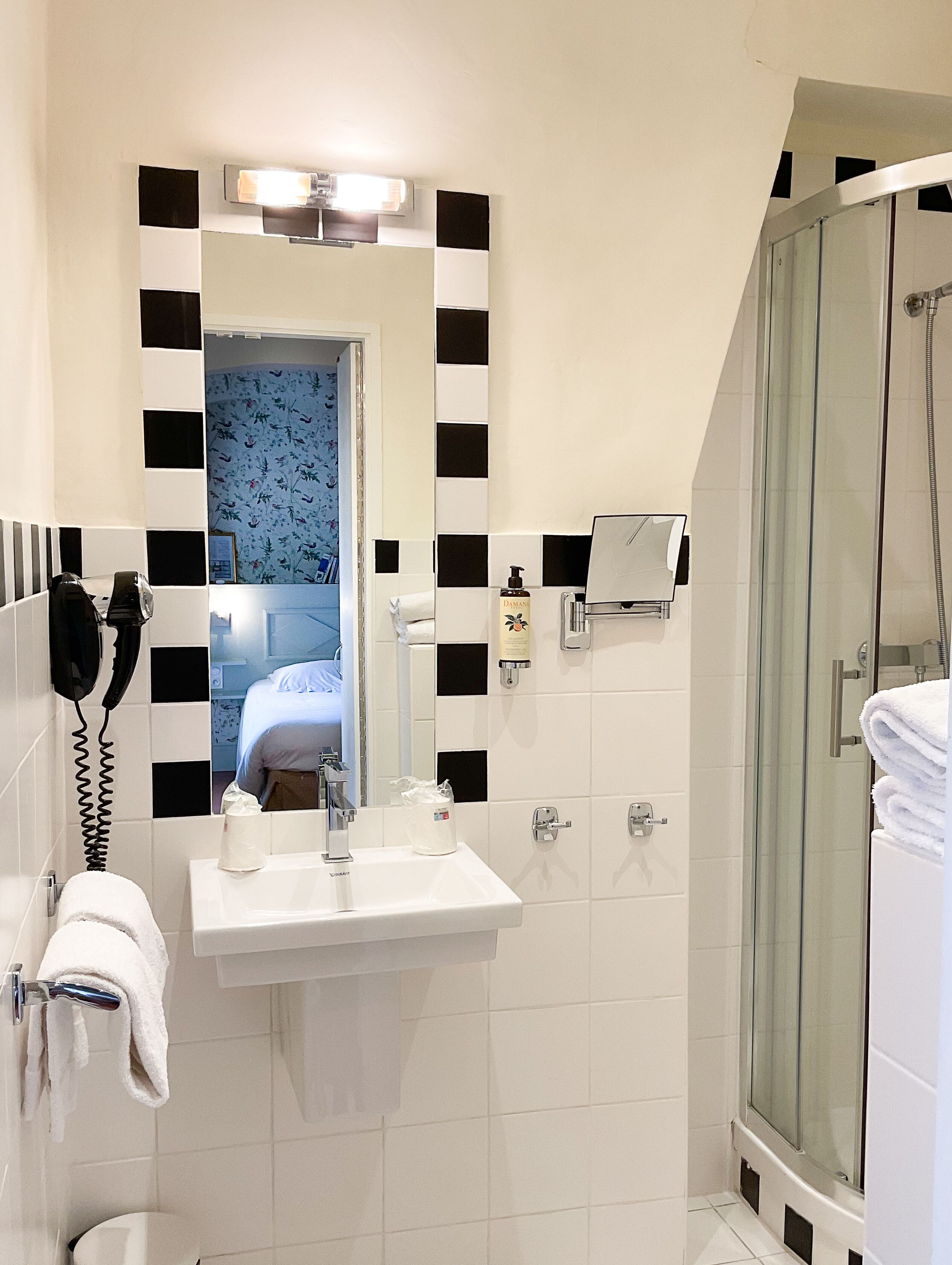 Un baño con lavabo, espejo y ducha.