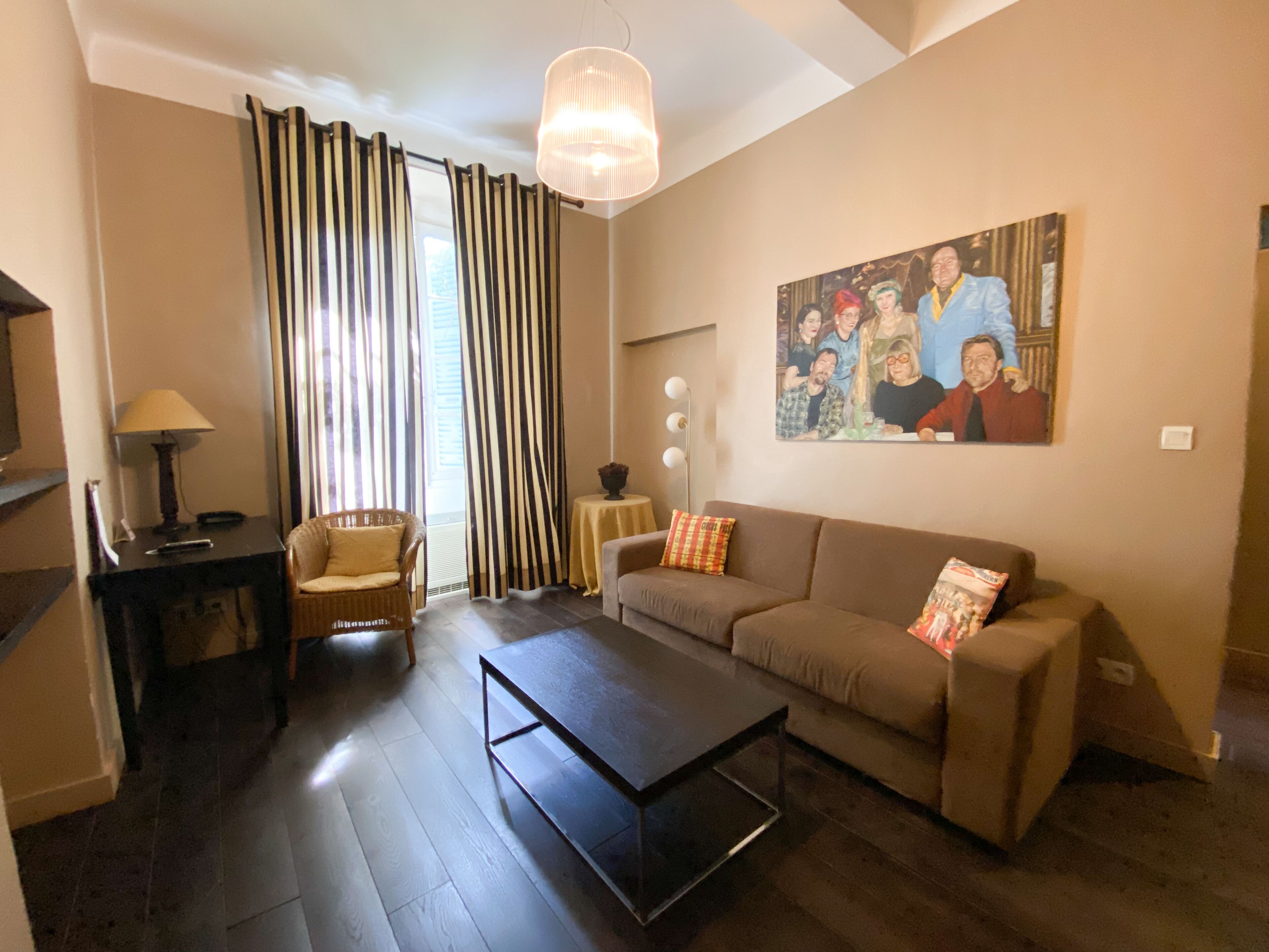 A living room with a sofa, a coffee table, a lamp, a chair, and a painting on the wall.