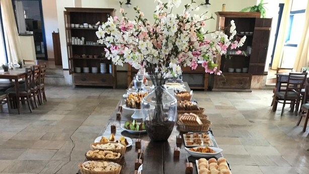 Une table de buffet garnie de divers plats et agrémentée d’un arrangement floral.