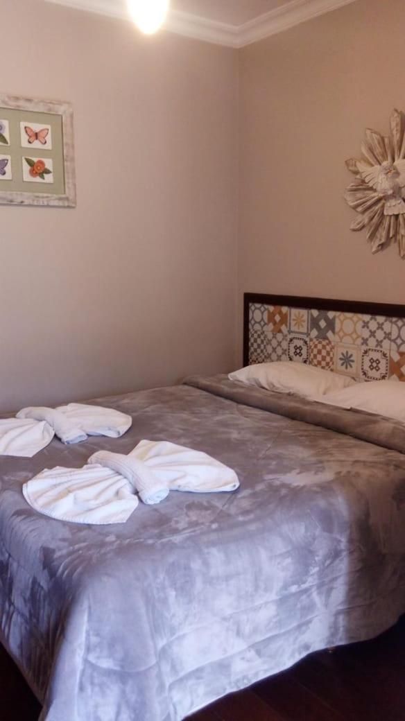 A hotel room with two beds, a decorative headboard, and a wall with a floral pattern.