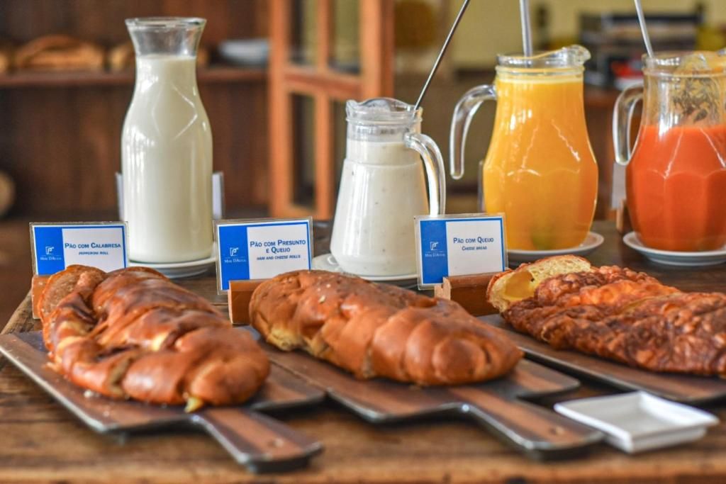 A breakfast buffet with various bread options and beverages.
