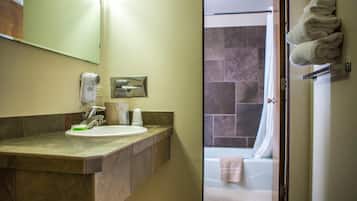 A bathroom with a sink, a hairdryer, and a towel rack.