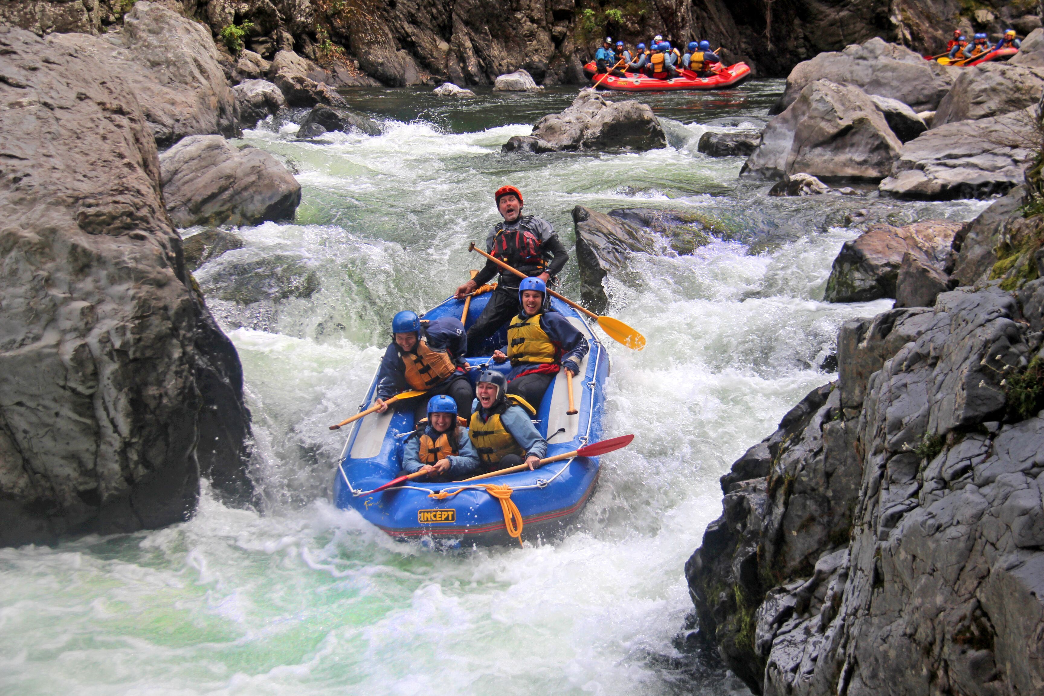Un grupo de personas haciendo rafting por un río con rápidos.