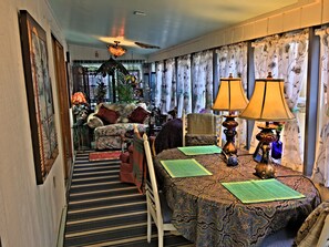 A cozy living room with a sofa, two chairs, a patterned table, and a staircase leading to another room. - Causeway Bike Path steps away with Water access and Kayaks. (Colchester)