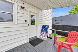 A covered porch with a door, a red chair, and a poster advertising All Star Rentals.