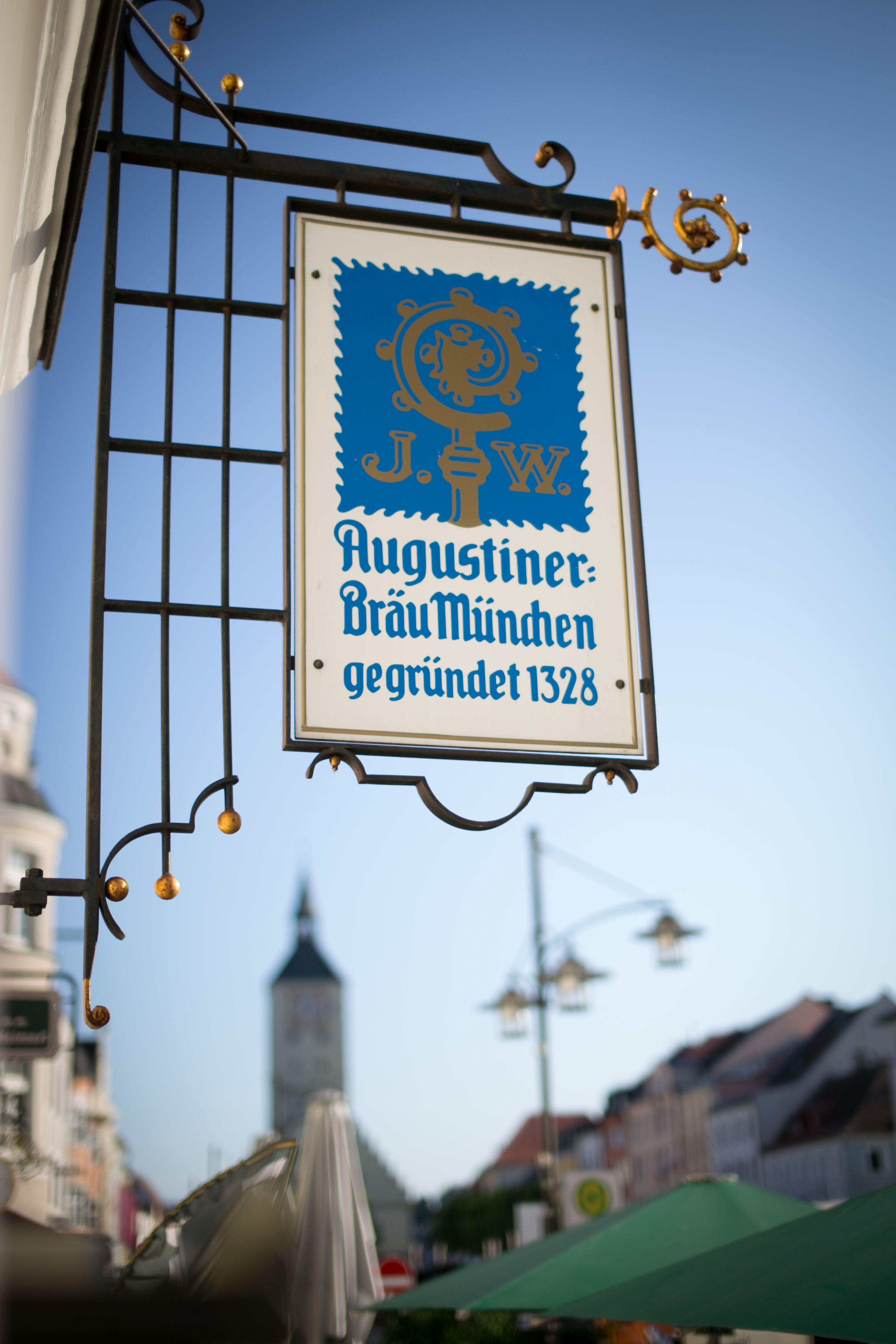 A sign with a blue and white design, hanging from a metal structure.