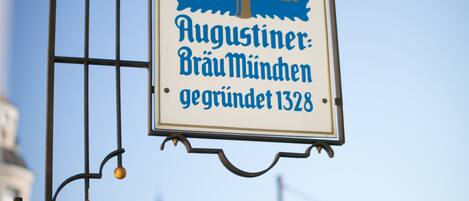 A sign with a blue and white design, hanging from a metal structure.