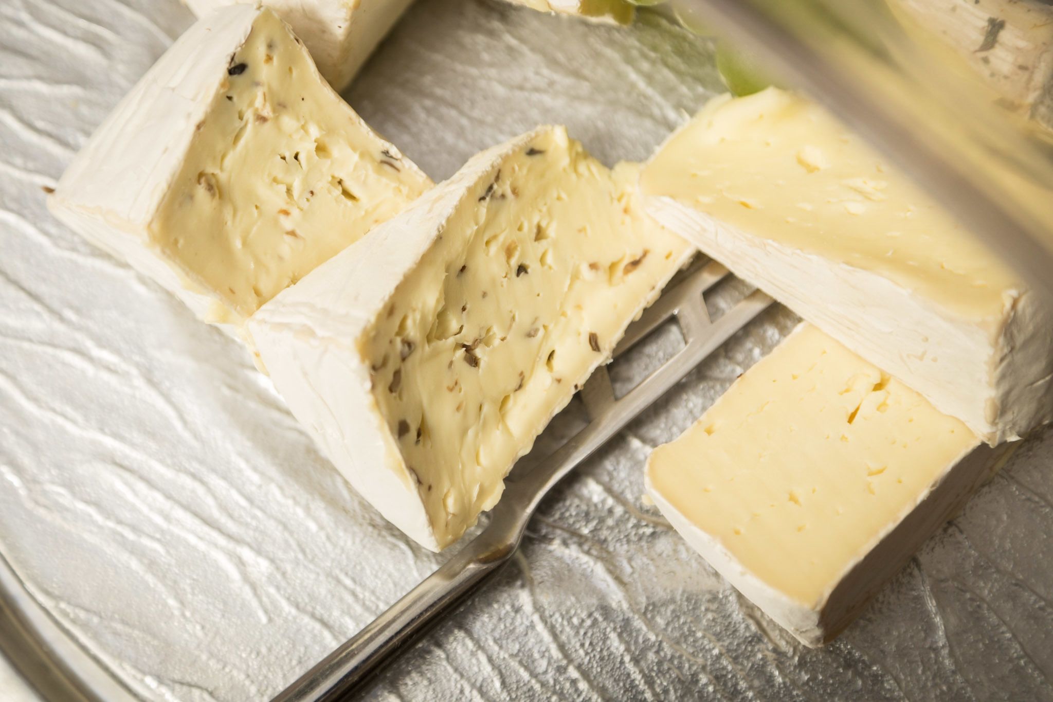 Un bloque de queso con un cuchillo y un tenedor.