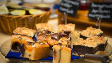 Una varietà di dolci su un piatto di vetro, tra cui torte e pasticcini.