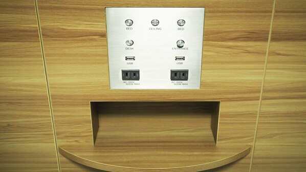 A wall-mounted electrical panel with labeled switches for bed, ceiling, desk, and entrance, two USB ports, and two AC outlets with 100V 600W max. - Hotel WBF Namba Motomachi (Osaka)