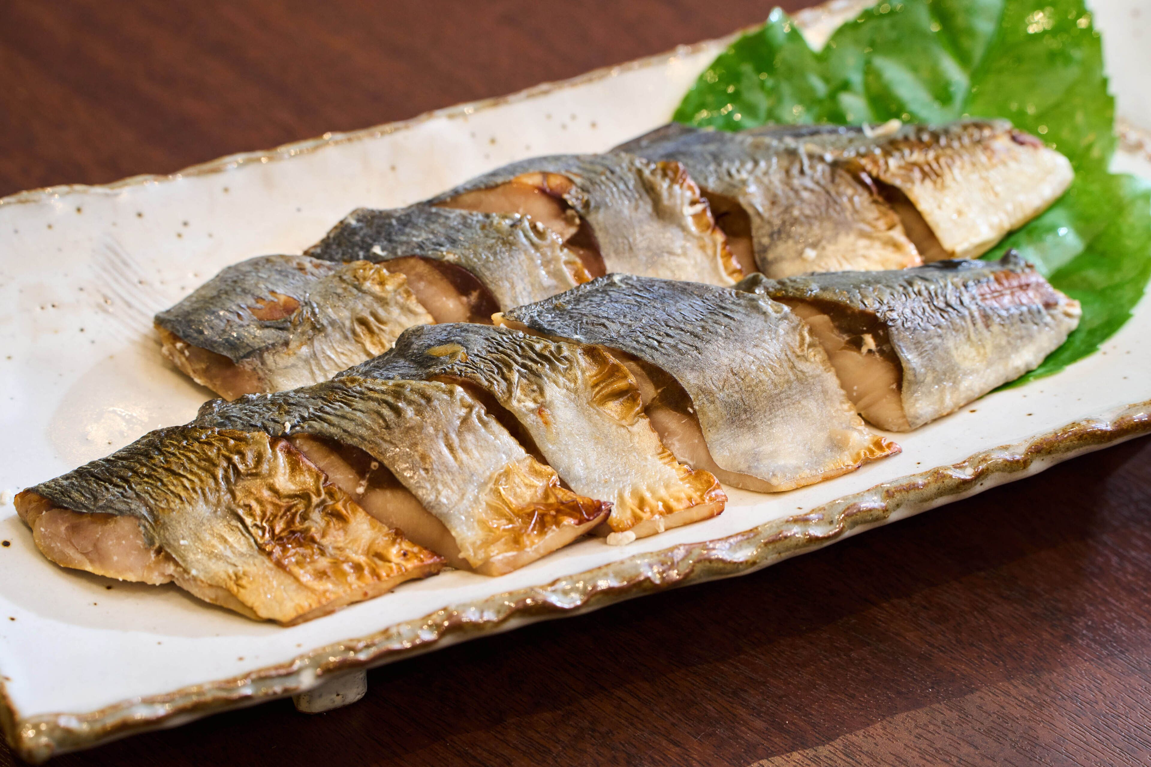 Une assiette de poisson grillé, servie dans un plat en céramique.