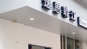 A building entrance with a sign reading "逸思玲江" and "Ease".