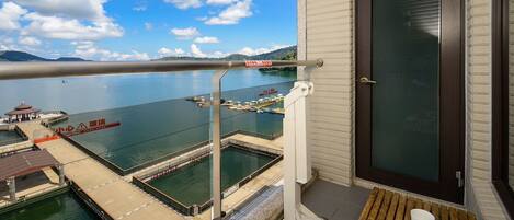 A balcony with a view of a swimming pool and dock area.