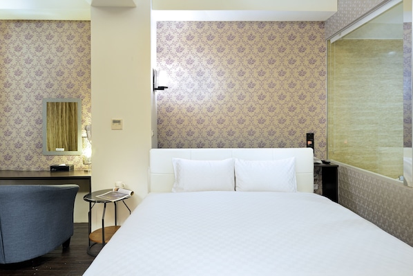 A hotel room with a large bed, a desk, a chair, and a small table. - Hu Yue Lakeview Hotel (Yuchi)