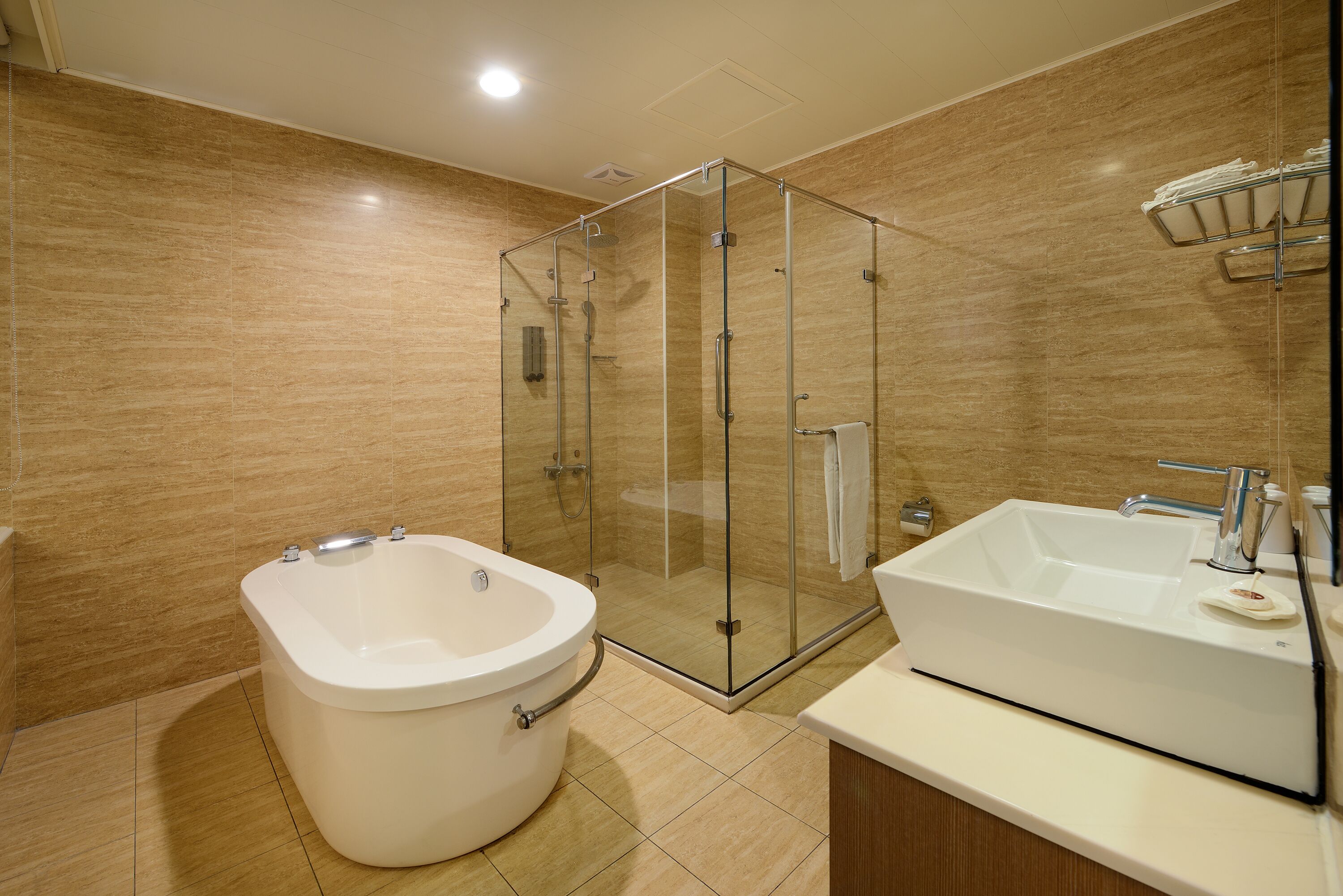 A modern bathroom with a glass-enclosed shower, a freestanding bathtub, and a sink with a mirror.