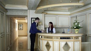 A reception area with a curved counter, a desk, and a potted plant. - Lowen-seckenheim (Mannheim)