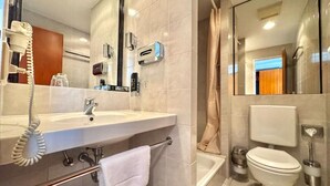 A modern bathroom with a large mirror, a sink, a toilet, and a shower area. - Lowen-seckenheim (Mannheim)