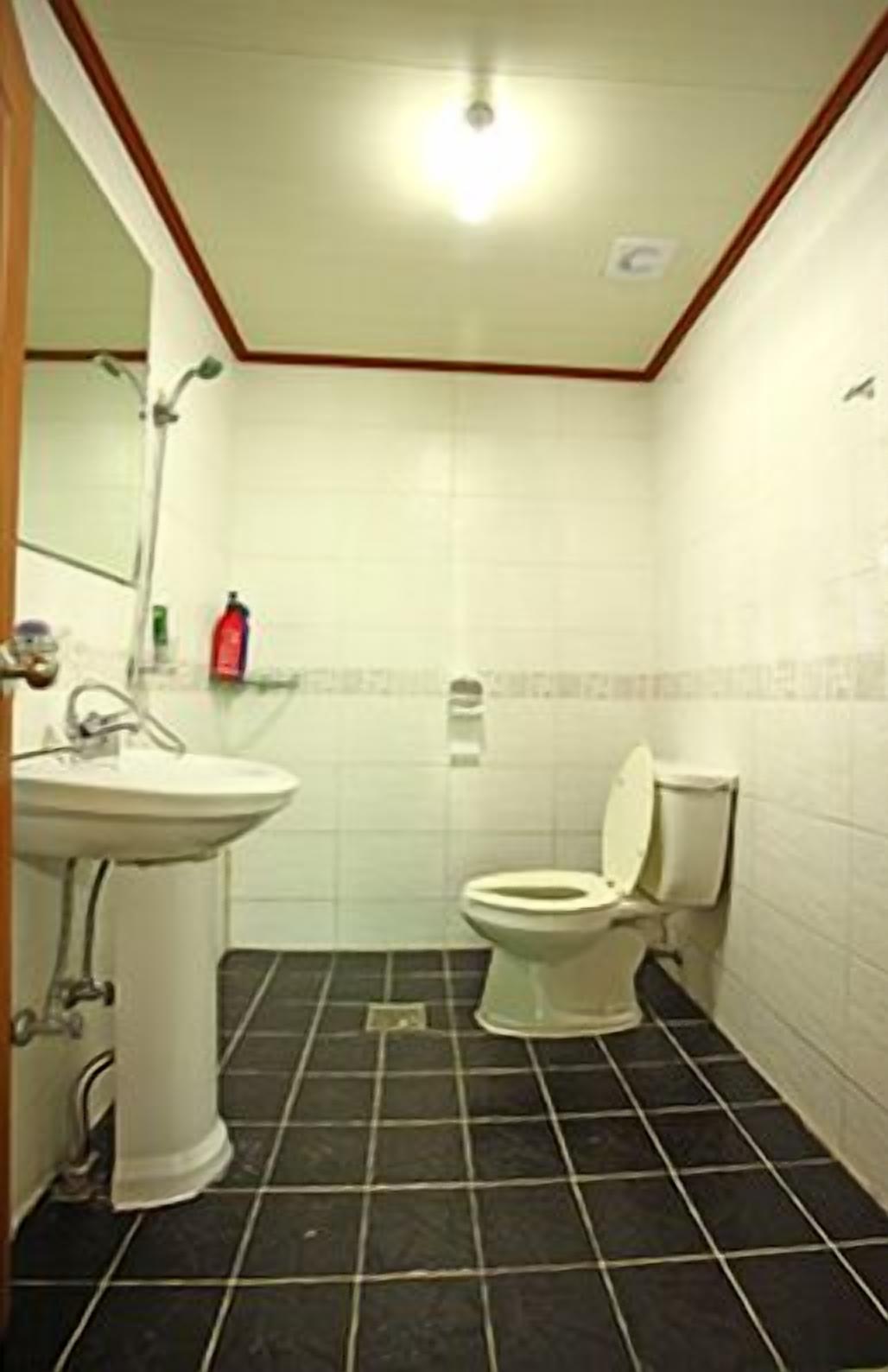 A small bathroom with a sink, toilet, and mirror.