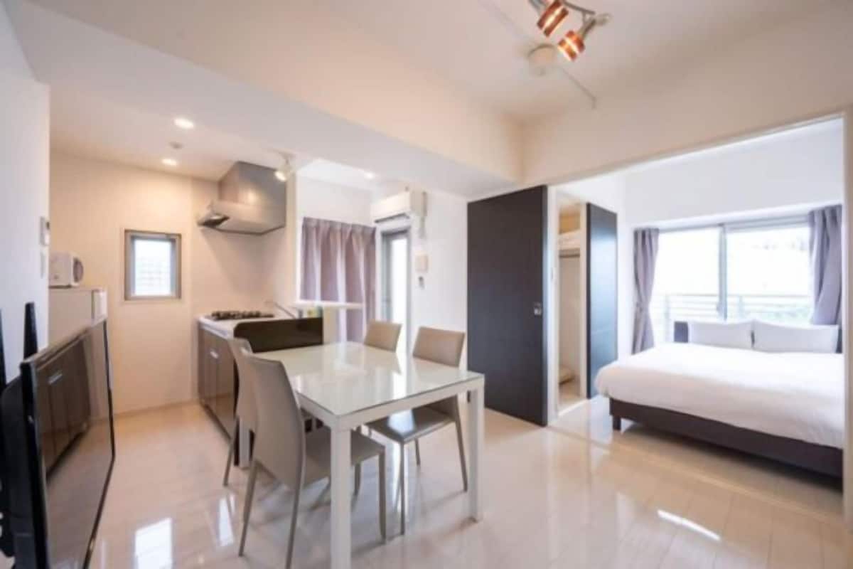 Ein modernes Hotelzimmer mit Essbereich, einem großen Bett und Blick auf die Stadt.