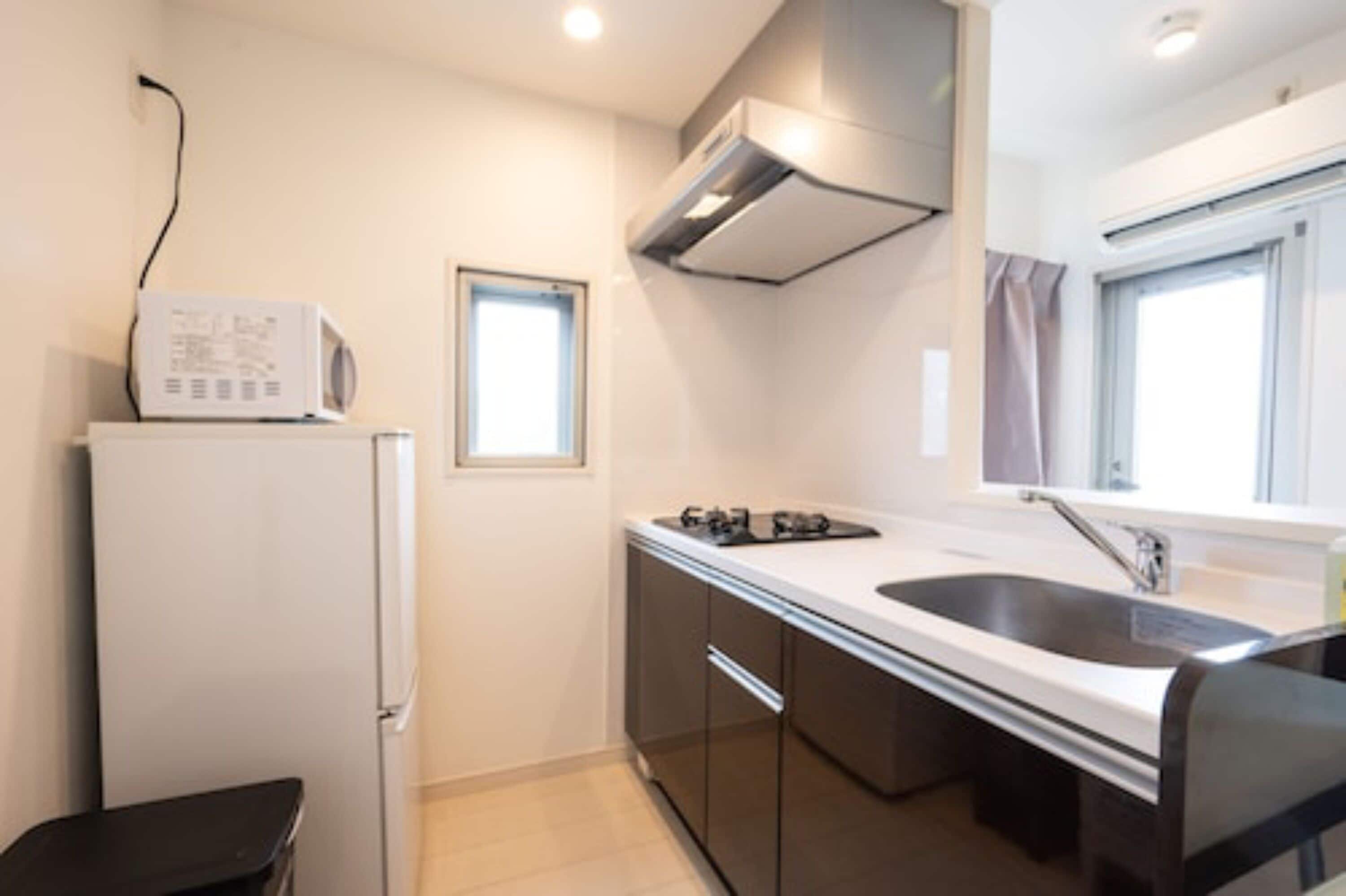 A modern kitchen with a built-in oven, a sink, and a window.