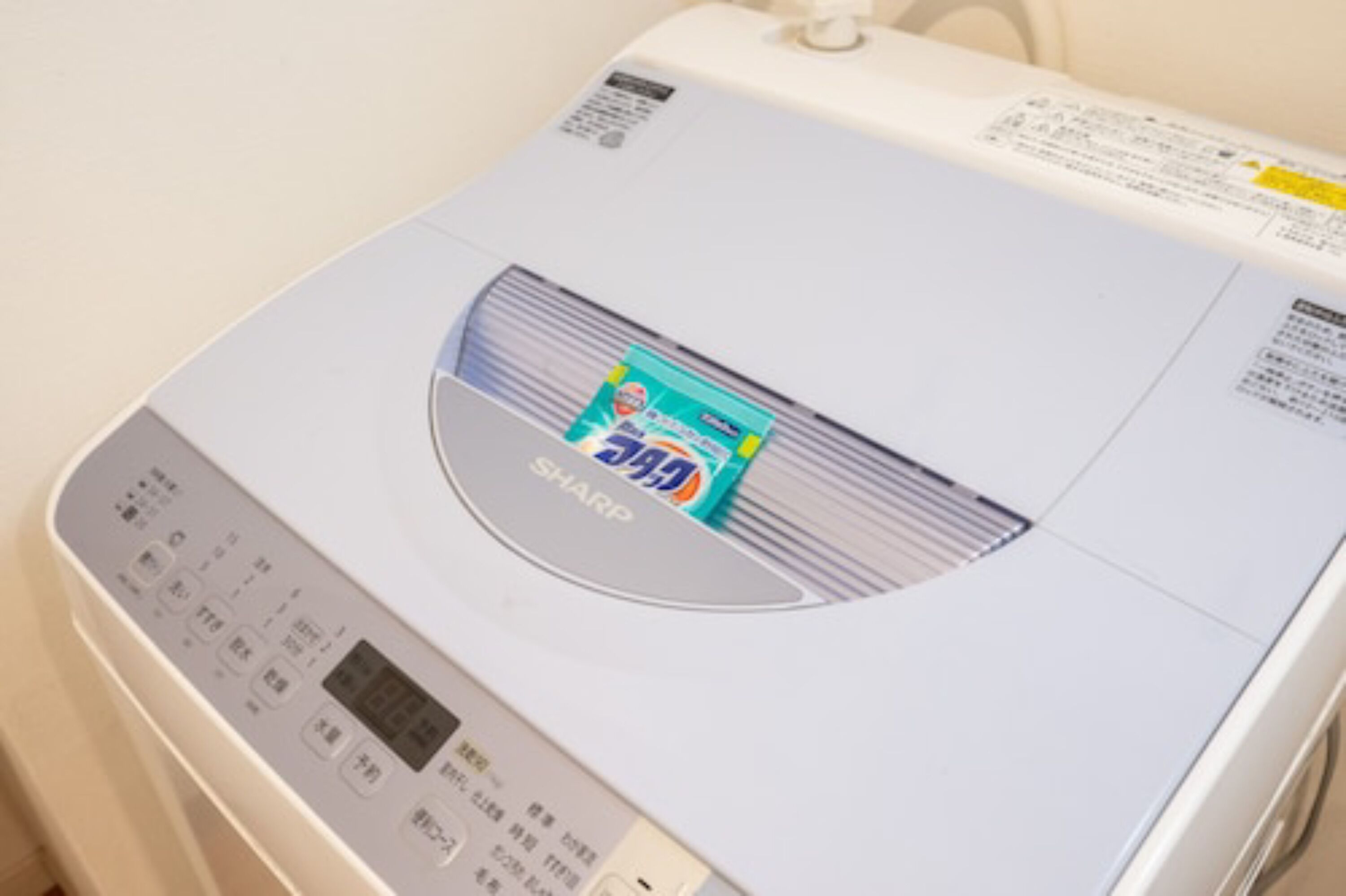 Un appareil électroménager moderne, de couleur blanche et de taille compacte, doté d’un écran numérique et d’un panneau de commande, qui pourrait être un four à micro-ondes ou un petit four.