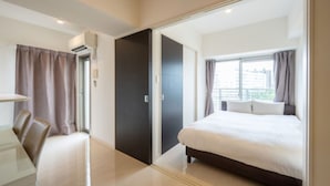 A modern hotel room with a large bed, a desk, and a wardrobe. - Residence Hotel Hakata 8 (Fukuoka)