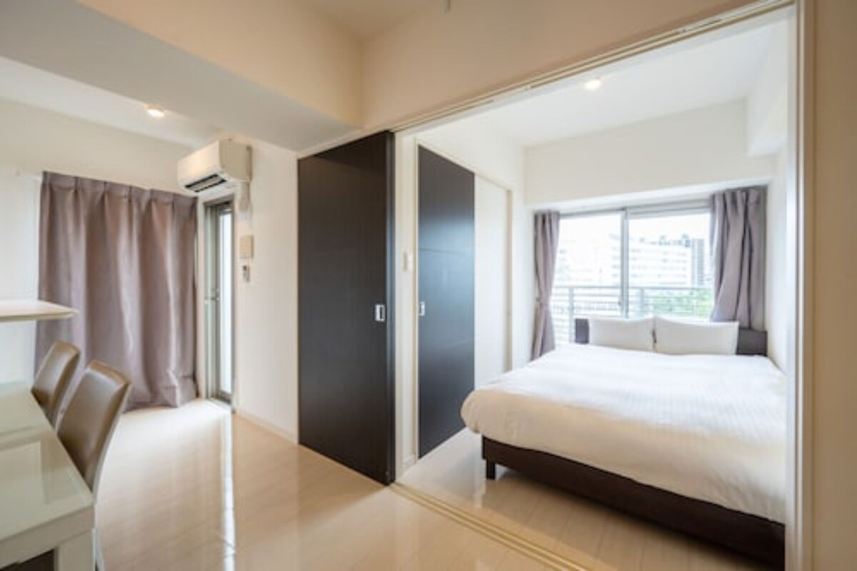 Een moderne hotelkamer met een groot bed, een bureau en een kledingkast.