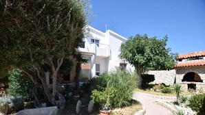 Un bâtiment blanc avec un chemin pavé menant à une porte.