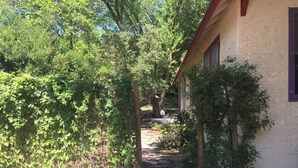 Un camí al jardí que condueix a una casa amb teulada vermella i parets blanques.