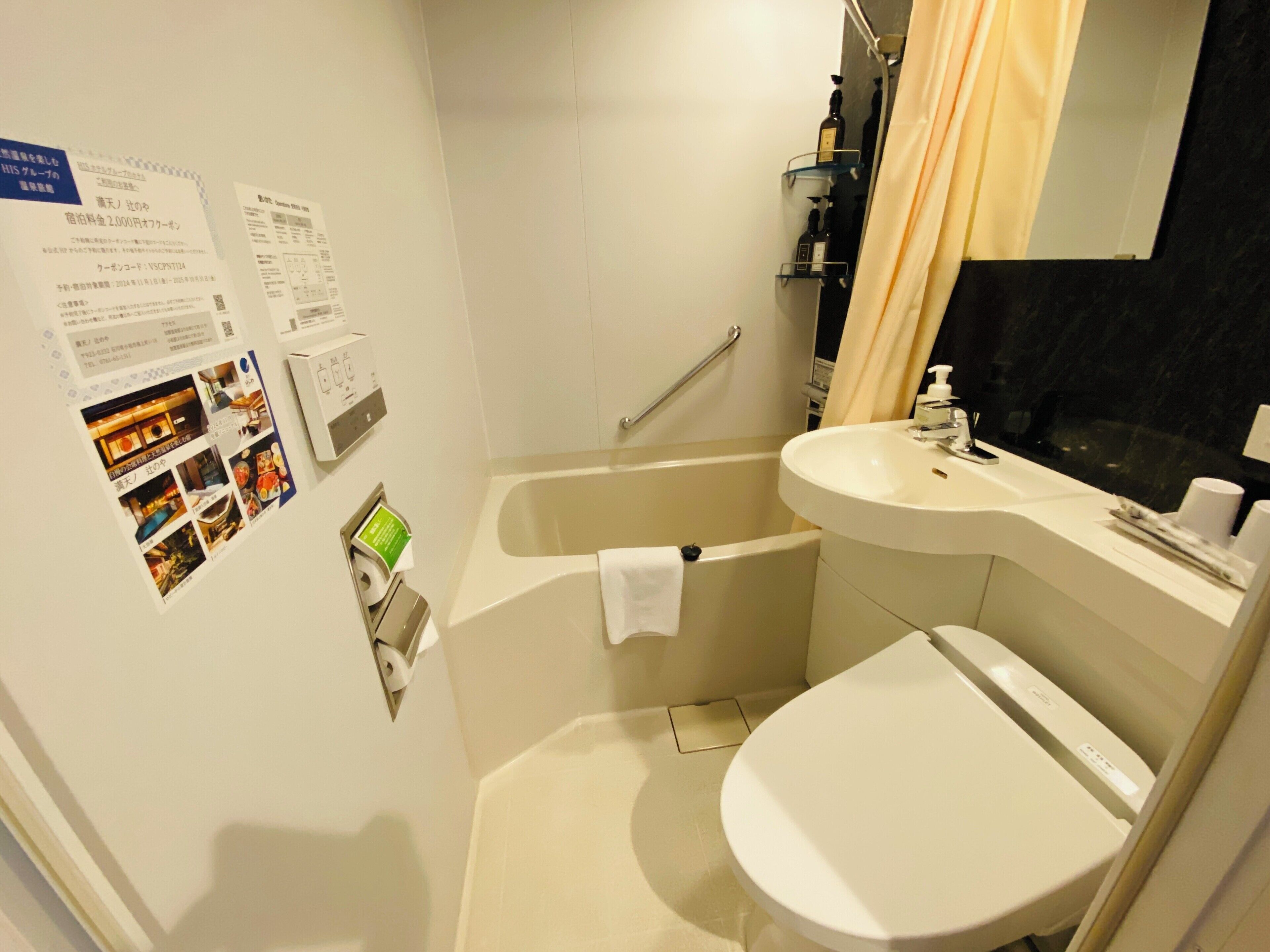 A bathroom with a bathtub, toilet, and sink. There are towels and toiletries on the sink.