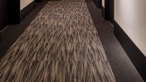 A long, narrow hotel corridor with carpeted floors and doors on both sides leading to rooms. - Henn na Hotel Tokyo Haneda (Tokyo)