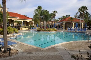 A swimming pool with lounge chairs and palm trees. - Family friendly villa, gated community, spa, heated pool, close to theme parks. (Kissimmee)