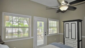 A bedroom with a bed, a wardrobe, and two windows with blinds. - Luxury Living in a Country Setting and Minutes to Lubbock! (Wolfforth)