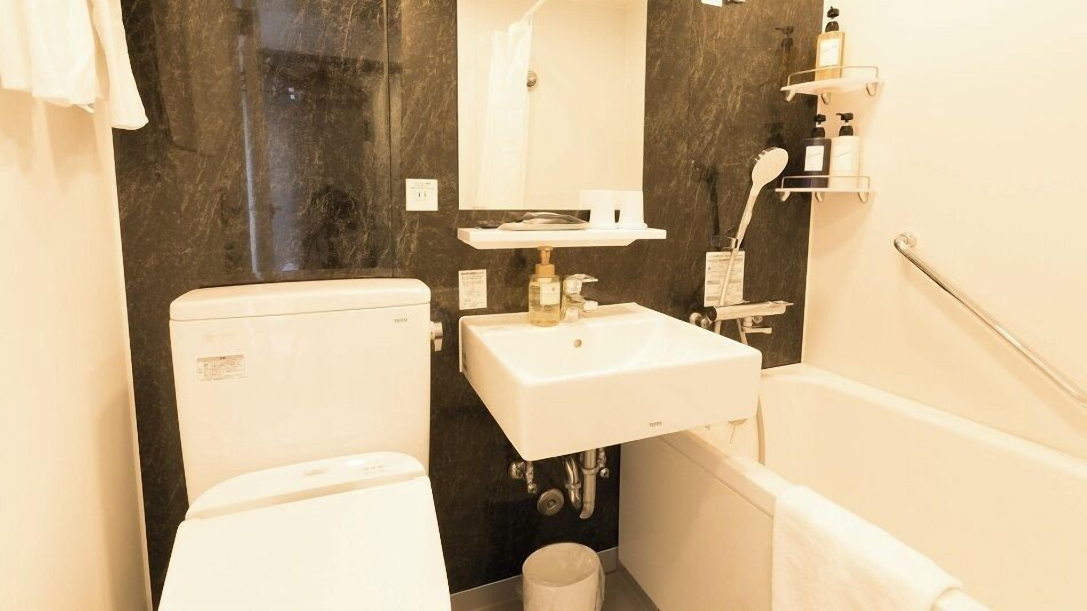 A compact bathroom with a toilet, sink, and bathtub.