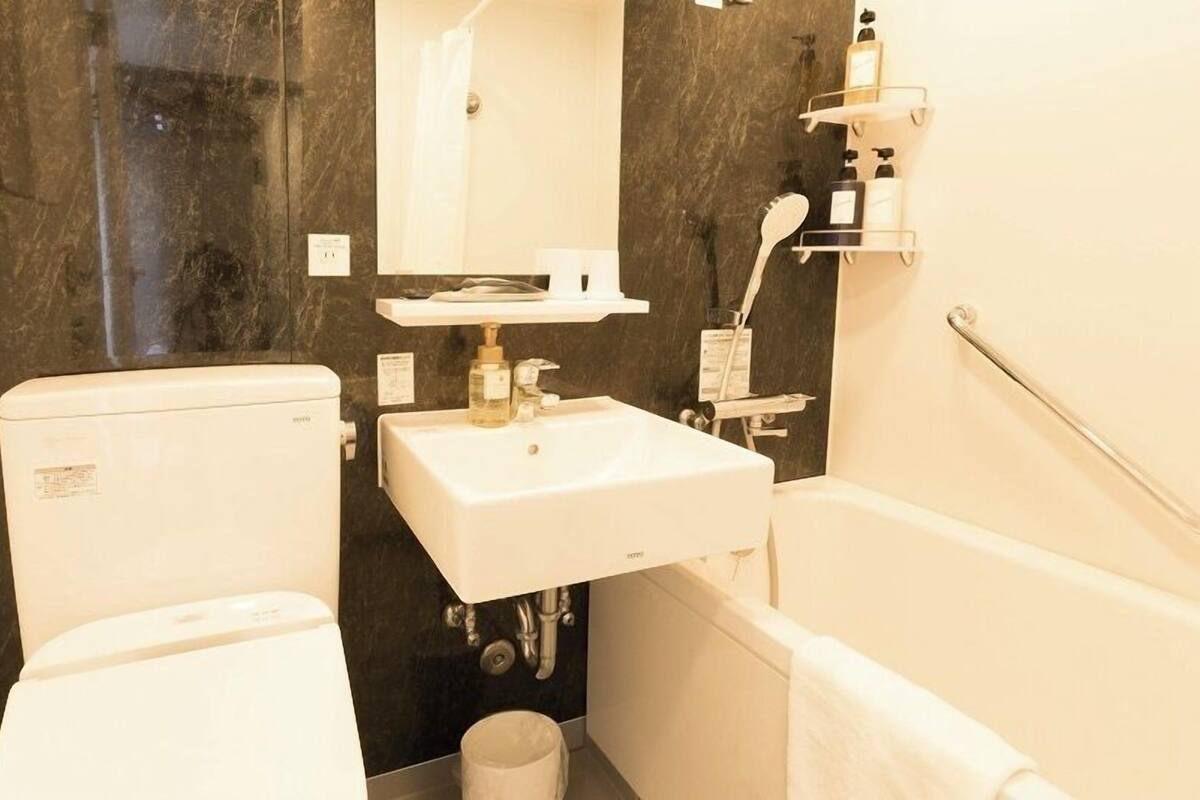Un baño pequeño con inodoro, lavamanos y bañera.