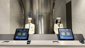 Un comptoir d’accueil avec deux employés, un écran numérique et un terminal de paiement.