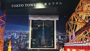Une chambre avec vue sur la tour de Tokyo, le paysage urbain et une maquette de grande roue.