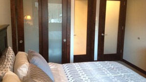 A bedroom with a bed, two wardrobes, and a nightstand with a lamp. - GREAT Ski-in, Ski-out Condo at Snow Flower at Park City Mountain Resort ! (Park City)