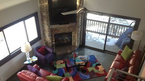 A spacious living area with a fireplace, leather sofas, and a colorful rug. - GREAT Ski-in, Ski-out Condo at Snow Flower at Park City Mountain Resort ! (Park City)