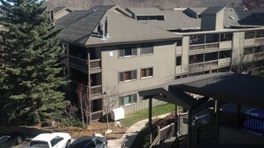 A multi-story residential building with a flat roof, balconies, and a view of a hilly landscape. - GREAT Ski-in, Ski-out Condo at Snow Flower at Park City Mountain Resort ! (Park City)
