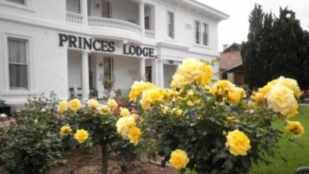 Un edificio blanco con un letrero que dice "PRINCES LODGE".