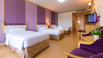 A hotel room with two beds, a TV, a desk, and a chair.