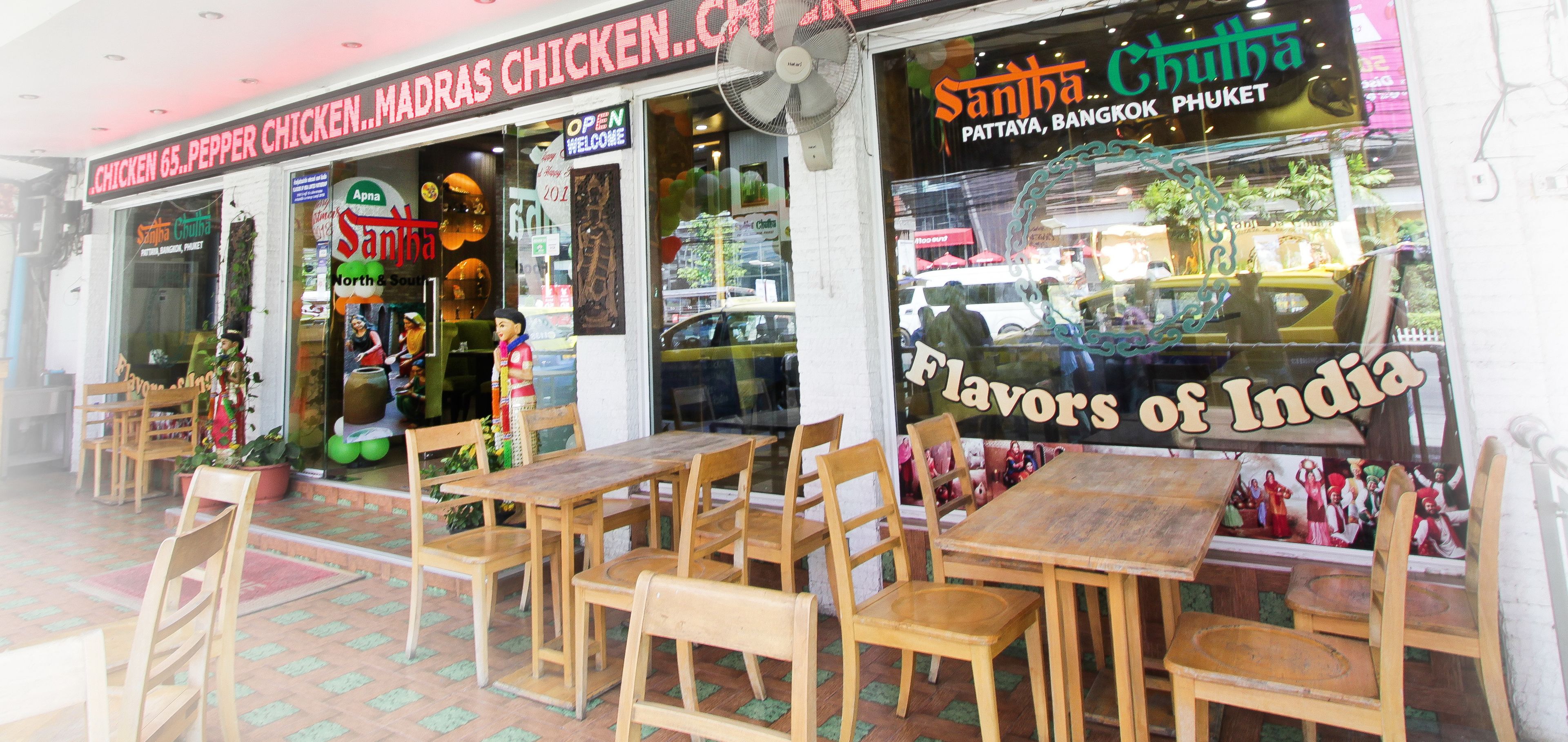 Un restaurante con mesas al aire libre y un cartel que anuncia 'Flavors of India'.