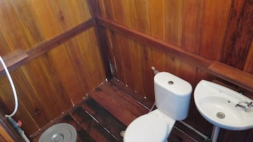 Un baño pequeño con piso de madera, un inodoro y un lavamanos.