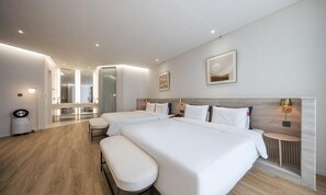 A modern hotel room with two beds, a small seating area, a mirror, and a view of the bathroom. - Brown Dot Hotel Masan (Changwon)