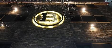 Un letrero de hotel con un gran logotipo iluminado en forma de 'B' y el nombre 'HOTEL BROWN-DOT' debajo.