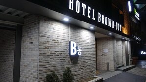 A hotel exterior with a brick facade and illuminated signage. - Brown Dot Hotel Masan (Changwon)