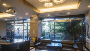 A modern interior with a bar area, seating, and large windows offering a view of the outdoors. - Hotel Hakata Nakasu Inn (Fukuoka)