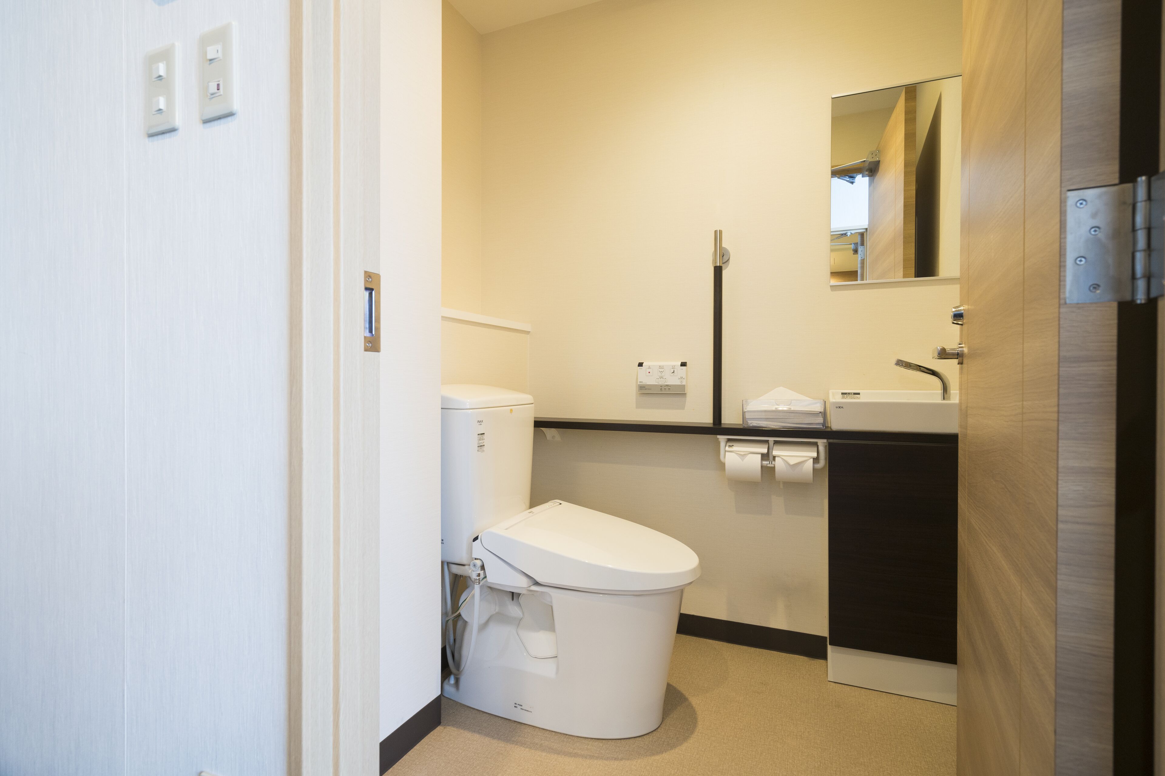 A compact bathroom with a toilet, sink, and mirror.