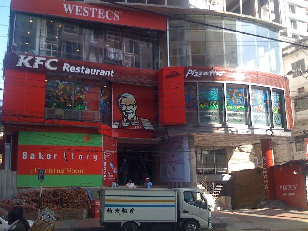 A building with multiple commercial spaces including a KFC Restaurant, a Pizza Hut, and a Baker Story.